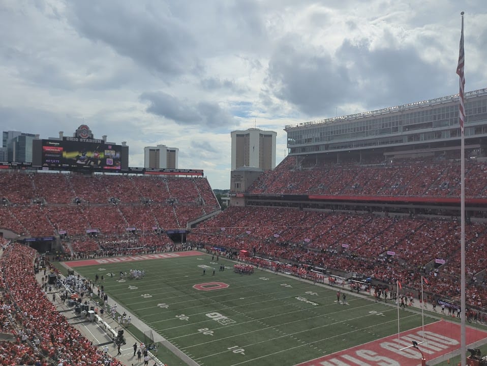 A football field and stadium full of fans wearing red in support of Ohio State Buckeyes